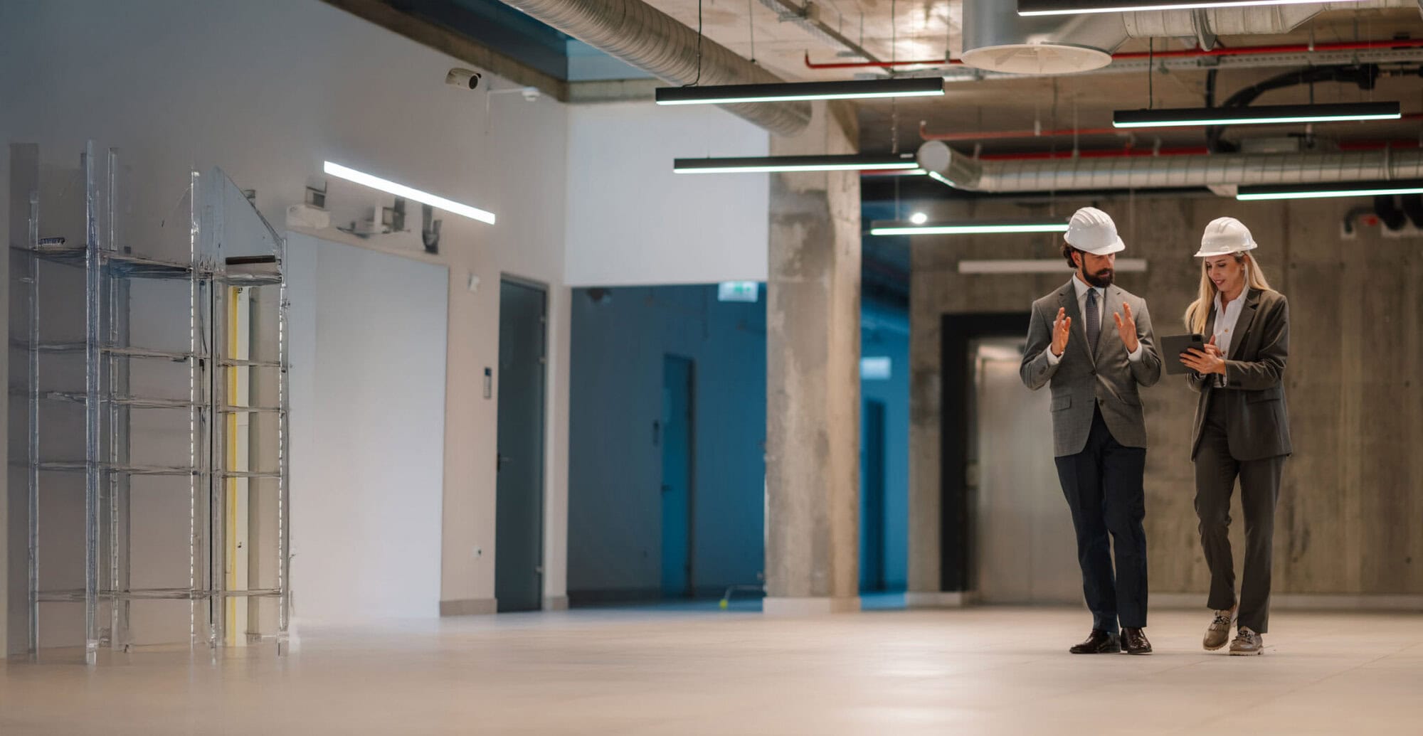 Two engineers discussing plans in modern building.